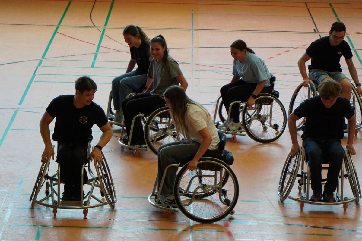 Schüler von FOSBOS Bayreuth fahren im Rollstuhl mit RSV Spieler