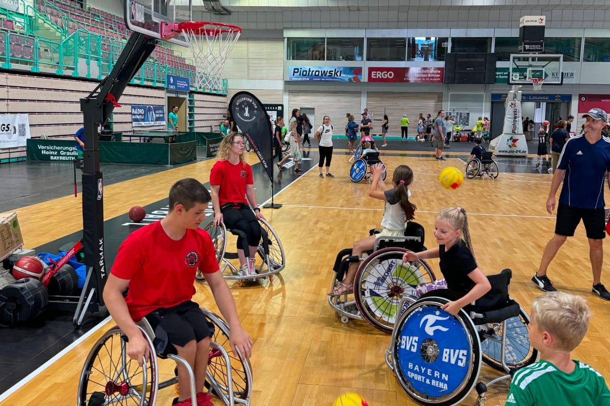 RSV Spieler mit Kindern in Sporthalle am Basketball spielen