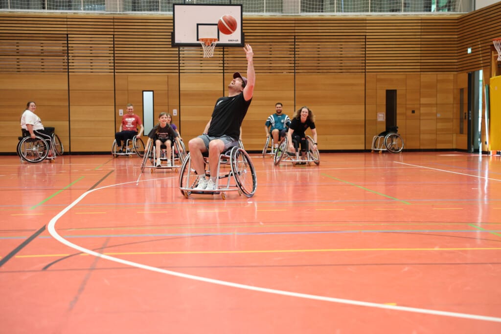 Personen fahren in der Sporthalle während einer den Ball wirft