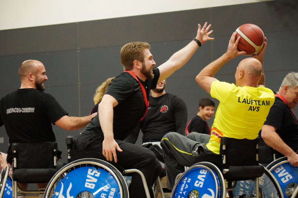 Mann wird beim werfen von Basketball von anderem Mann geblockt