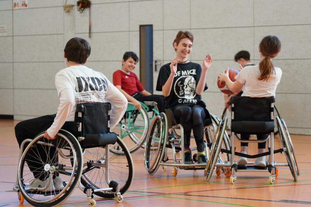 Schüler spielen Rollstuhlbasketball in Sporthalle